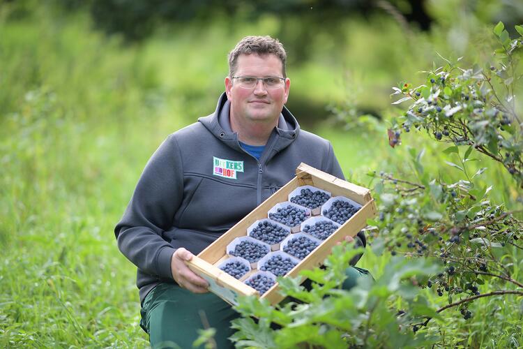 Christoph Decker mit einer Kiste Heidelbeeren