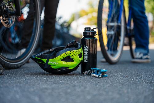 Helm und Trinkflasche auf Asphalt