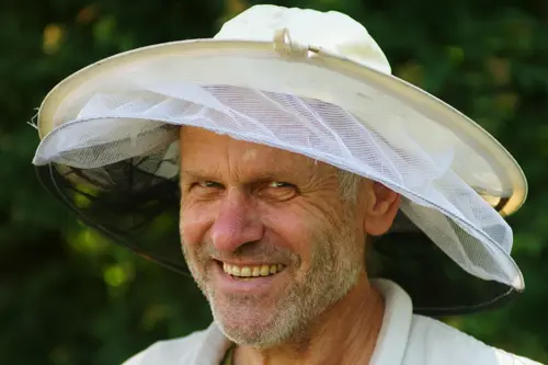 Imkermeister Günter Friedmann in Umgebung mit Bienenvölkern