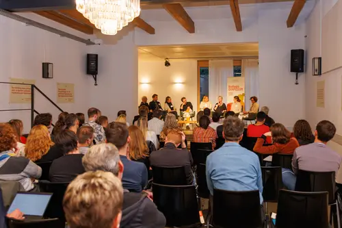 Zuhörer lauschen Podiumsdiskussion